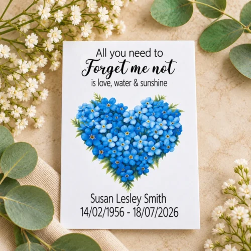 White personalised funeral seed packet featuring a blue forget me not flower heart, name and dates.